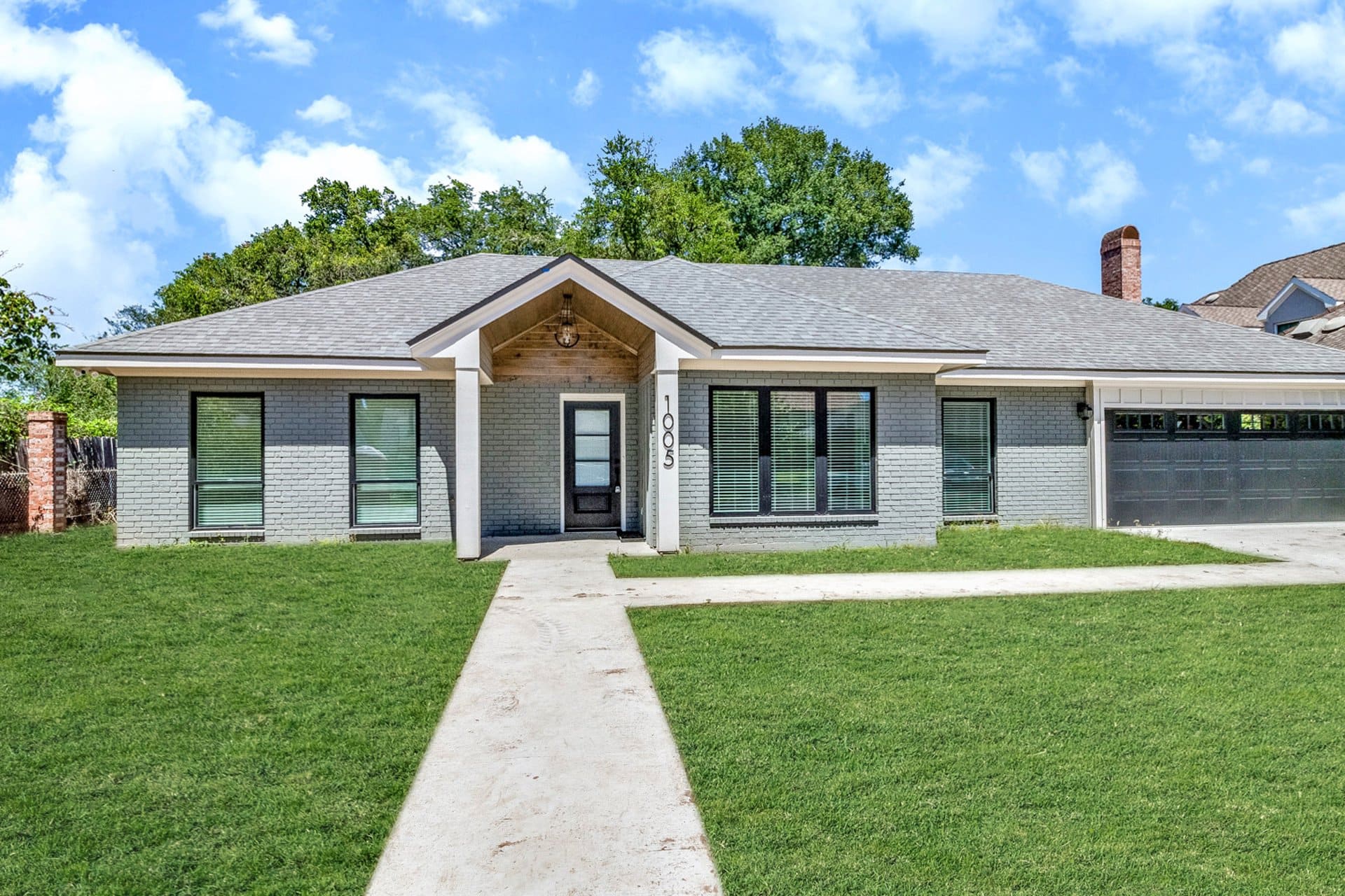 A home with a garage and grass in the front yard.
