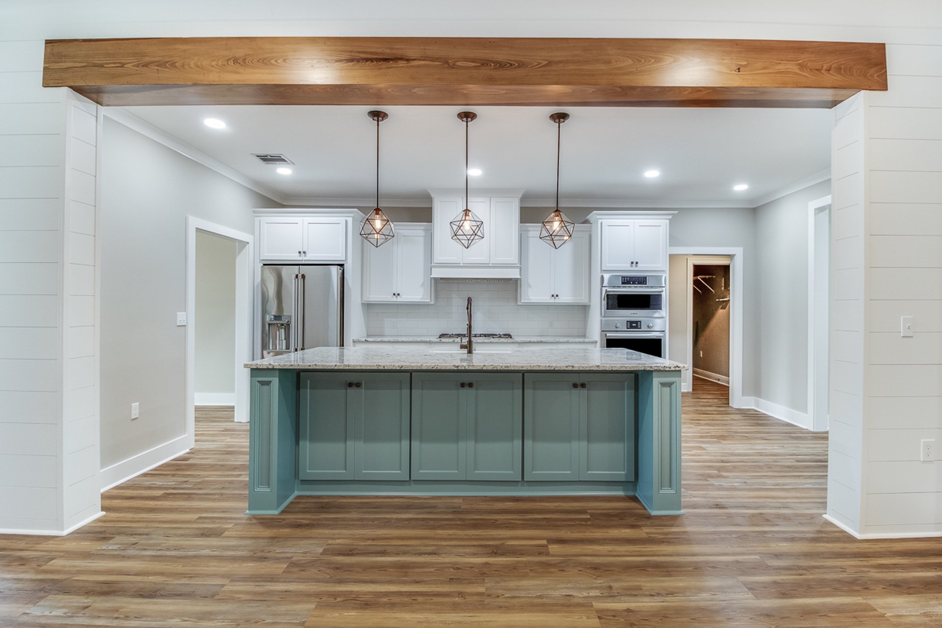 A kitchen with hardwood floors and a blue island.