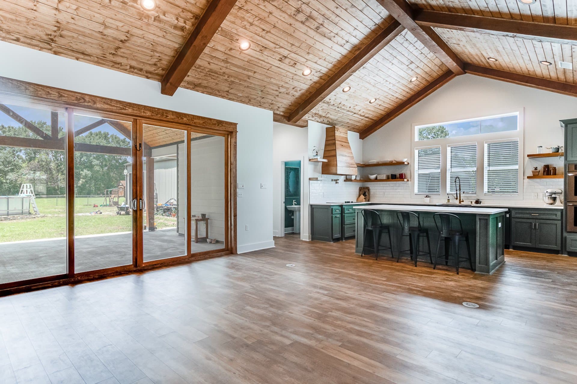 A kitchen with wood ceilings and sliding glass doors.