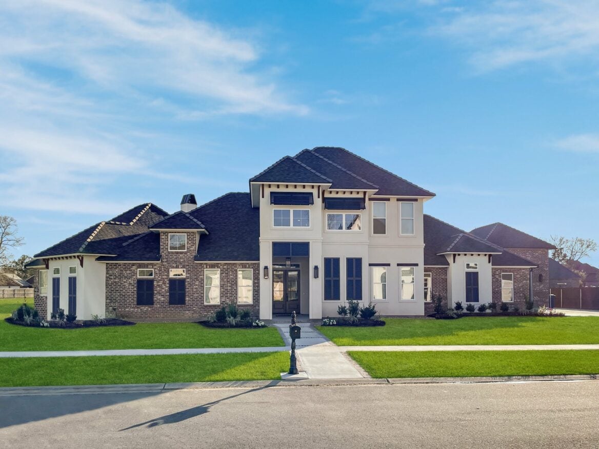 A large home with a large lawn in front of it.